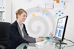 Businesswoman analyzing graph on computer