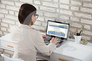 Businesswoman Analyzing Graph On Laptop