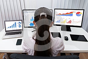 Businesswoman Analyzing Graphs On Computers