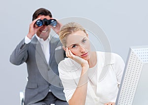 Businesswoman annoyed by a man using binoculars