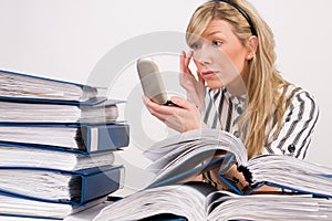 Businesswoman applying makeup