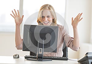 Businesswoman With Arms Raised Celebrating Success While Looking