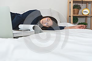 businesswoman attractive and young, sleeping on white bed while working