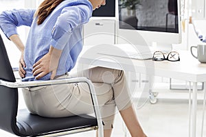 Businesswoman with back pain in office