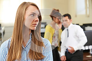 Businesswoman Being Gossiped About By Colleagues In Office