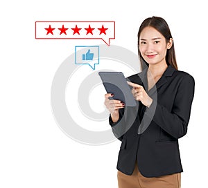 Businesswoman in black suit typing on tablet computer, show five stars best rating feedback and thumbs up icon. Customer service