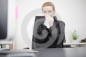 Businesswoman Blowing her Nose at her Office