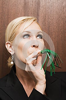Businesswoman blowing party blower
