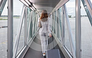 Businesswoman boarding the plane with carry-on