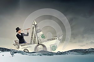 Businesswoman in boat made of dollar banknote