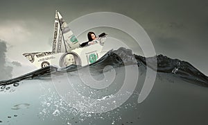 Businesswoman in boat made of dollar banknote