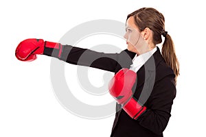 Businesswoman with boxing gloves punching and hitting standing i