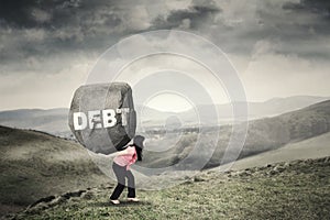 Businesswoman brings rock with Debt word photo