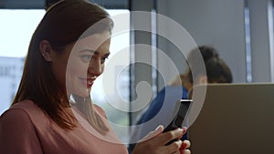 Businesswoman browsing internet on smartphone. Employee using mobile phone