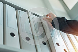 Businesswoman browsing through ring binder file documentation archives