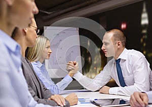 Businesswoman and businessman arm wrestling