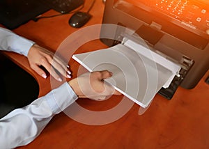 Businesswoman businessman put paper sheet into printer tray