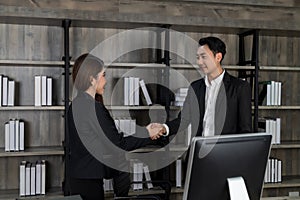 businesswoman and businessman shaking hands with positive mood in work office. successful contract business. negotiation meeting