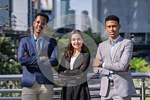 businesswoman and businessman standing, crossing arm, looking at camera.