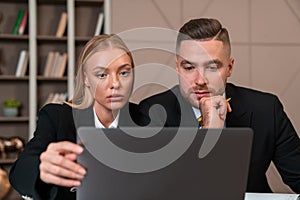 Businesswoman and businessman wearing formal wear sitting workin