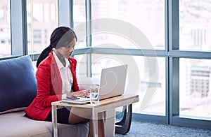Businesswoman busy typing on her computer in modern business lounge