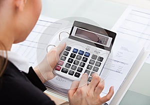 Businesswoman calculating bills