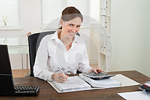 Businesswoman Calculating Invoice
