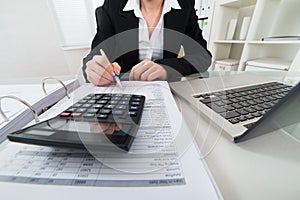 Businesswoman Calculating Invoice