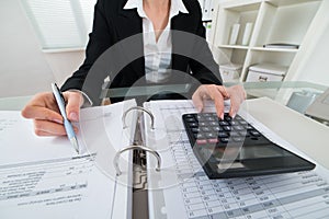 Businesswoman Calculating Invoice