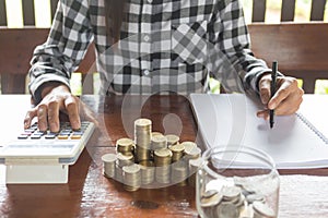 Businesswoman with calculator counting making notes, hand is writes in a notebook, Savings Account Money Finance