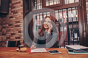 Businesswoman calling on mobile phone and taking notes