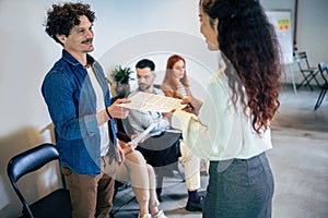 Businesswoman with candidate next to people waiting for job interview in the office