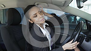 Businesswoman in car looking in rear-view mirror, overconfidence, narcissism