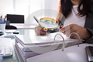 Businesswoman Checking Bill Through Magnifying Glass