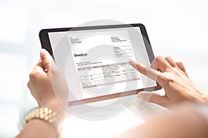Businesswoman Checking Invoice On Digital Tablet
