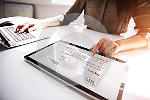 Businesswoman Checking Invoice On Digital Tablet