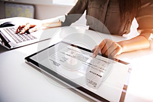 Businesswoman Checking Invoice On Digital Tablet photo