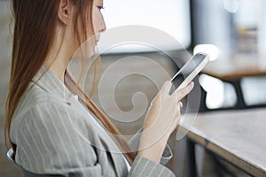 Businesswoman Checking Mobile Device in Office.