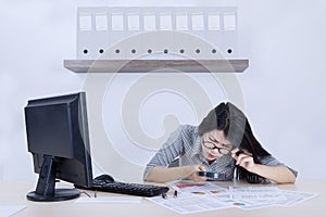 Businesswoman checks a declining chart with magnifier photo