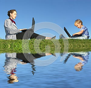 Businesswoman and child sit with notebooks