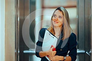 Businesswoman with a Clipboard Riding an Elevator at Work