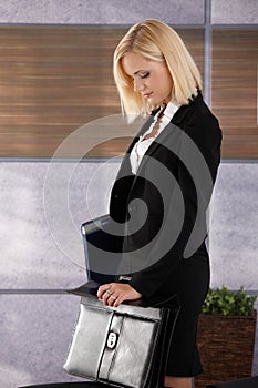 Businesswoman closing briefcase