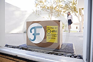 Businesswoman Coming Home To Fresh Food Home Delivery In Cardboard Box Outside Front Door