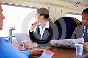 Businesswoman Commuting To Work On Train And Using Laptop