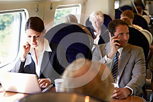 Businesswoman Commuting To Work On Train And Using Laptop