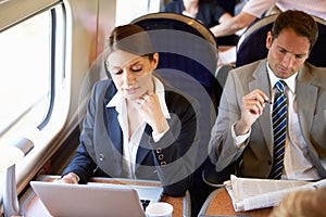 Businesswoman Commuting To Work On Train And Using Laptop photo