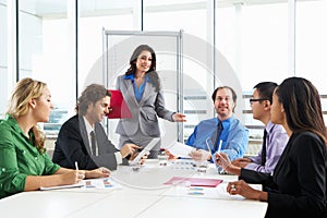 Businesswoman Conducting Meeting In Boardroom