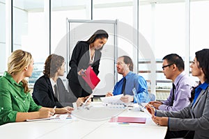 Businesswoman Conducting Meeting In Boardroom