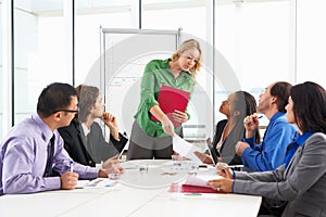 Businesswoman Conducting Meeting In Boardroom