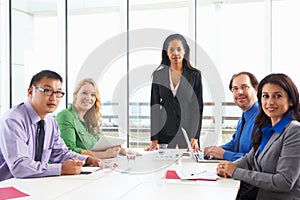 Businesswoman Conducting Meeting In Boardroom